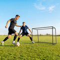 Black football goal with white net, soccer ball in front on field