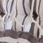 Close-up of cushion seams and braided rope fringe on striped hammock seat