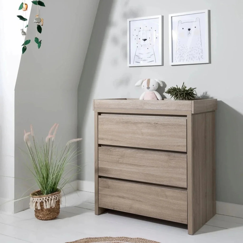 Oak changing unit with three drawers and flat top, rectangular cabinet design.