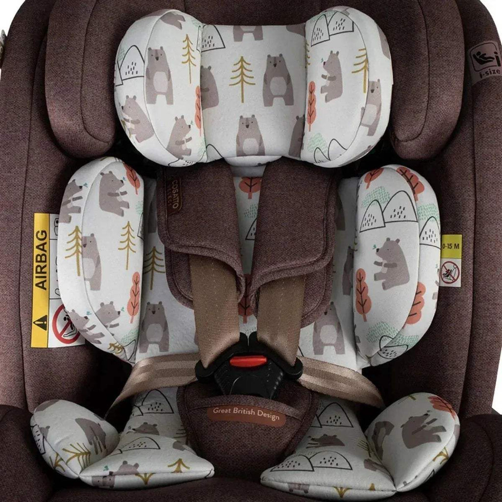 Brown car seat close-up with white animal and tree print cushions