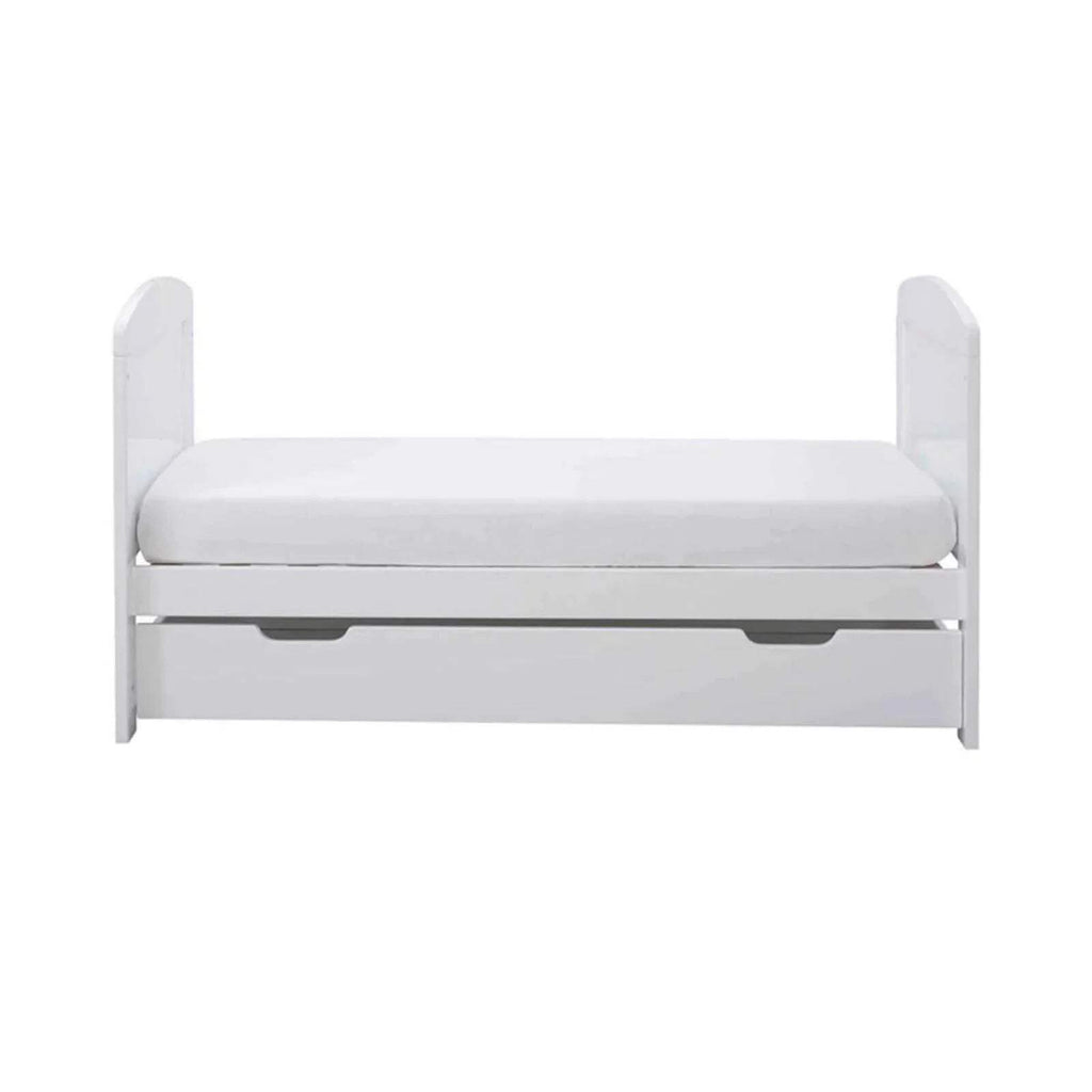 White mini cot bed with mattress and under-drawer panel, side view