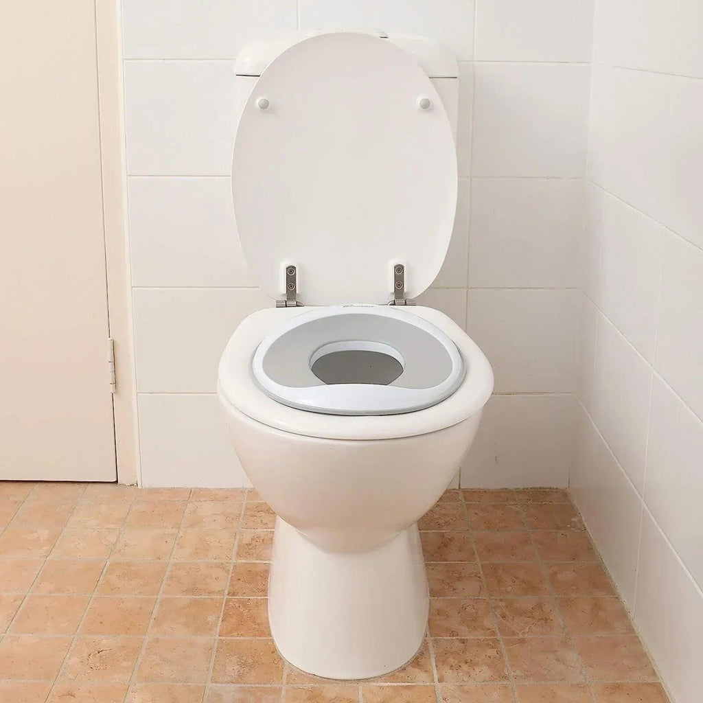 White toilet trainer seat topper on a standard toilet with oval opening