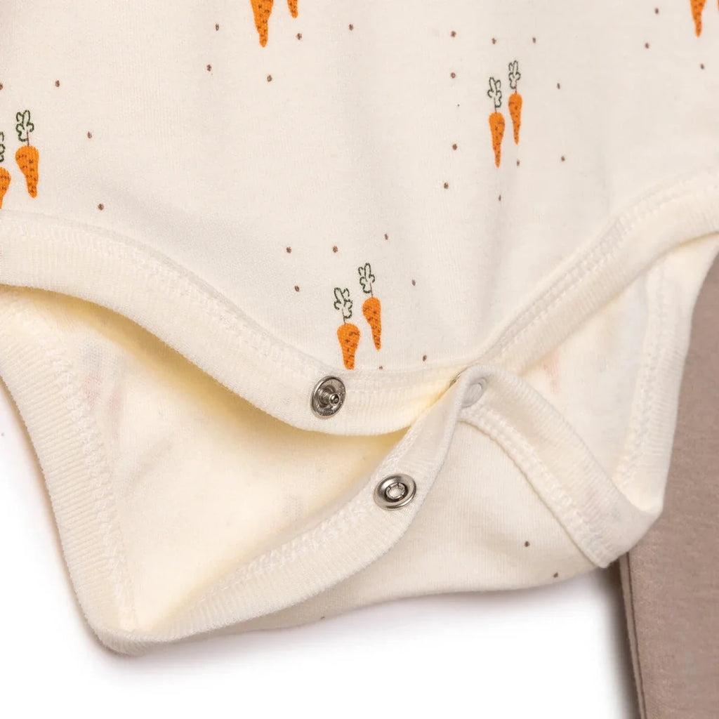 Cream bodysuit close-up with snap placket and carrot animal print