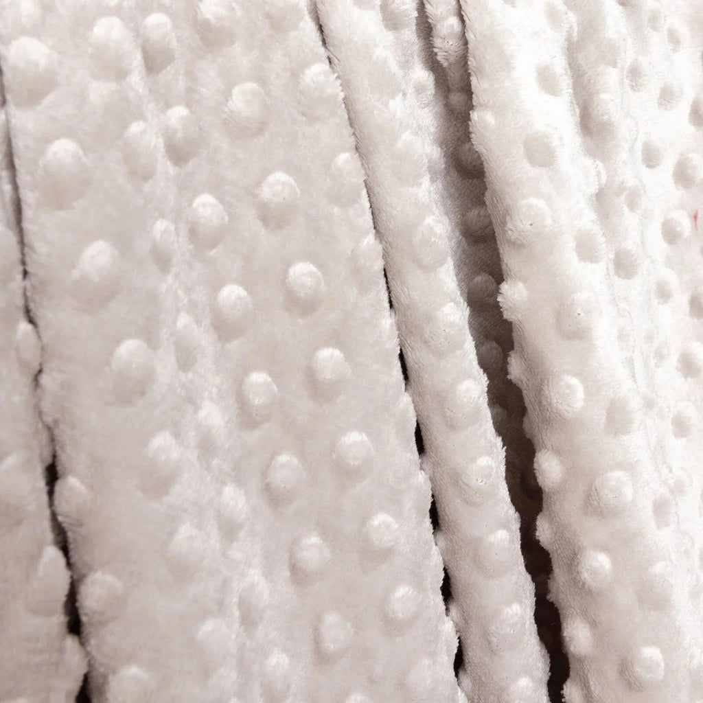 Close-up of beige fleece baby blanket fabric with raised dot texture