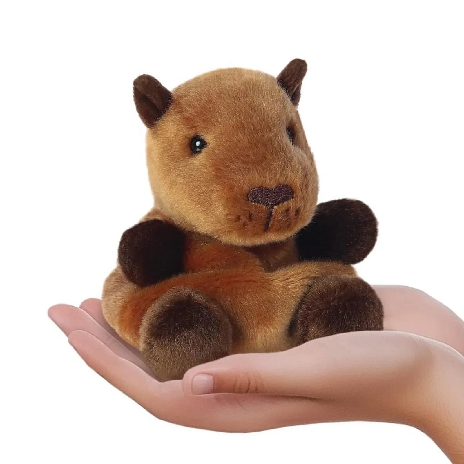 Capybara plush soft toy on open hands, tan fur with dark paws, 12 cm