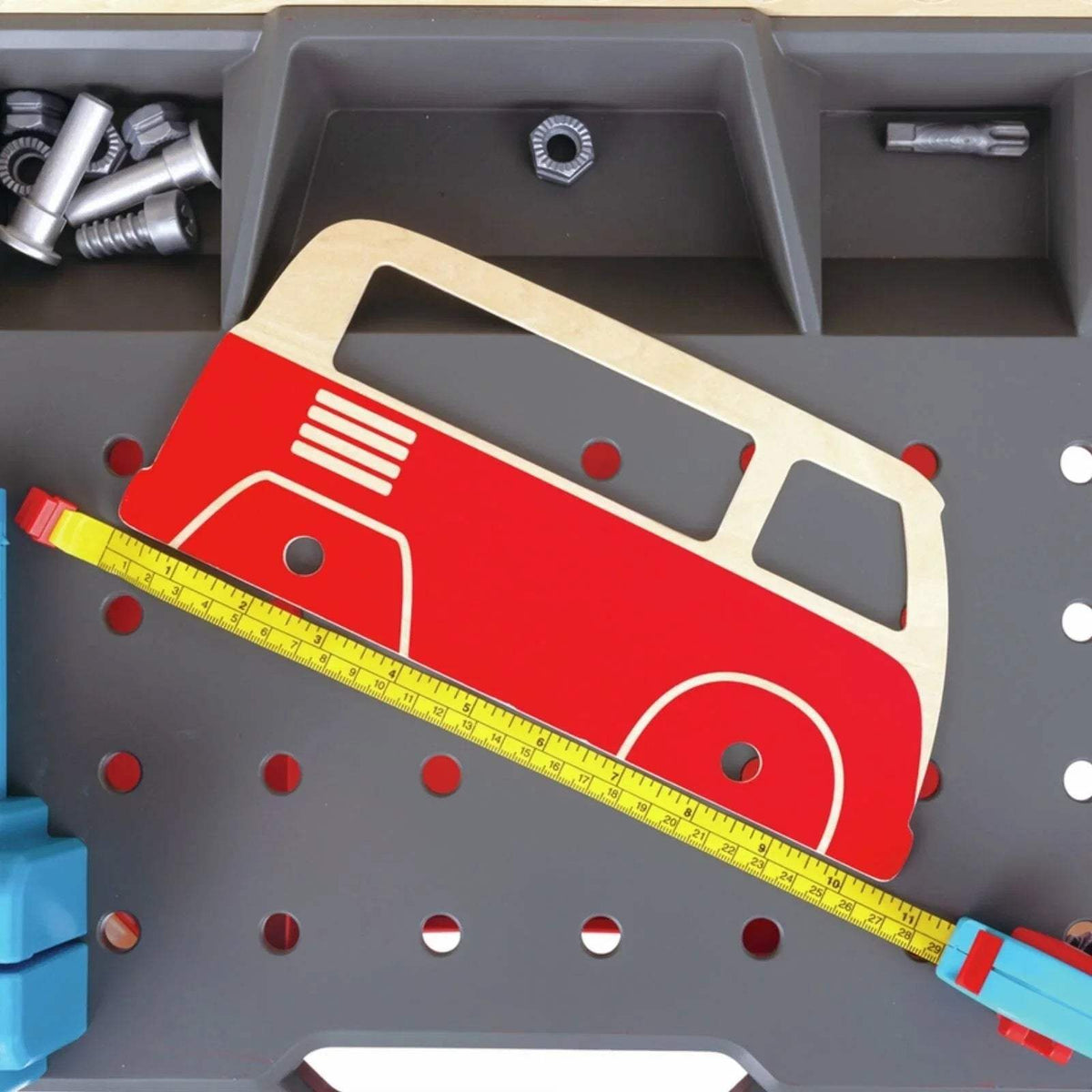 Toy car repair area with gray pegboard, red vehicle, and yellow ruler tool