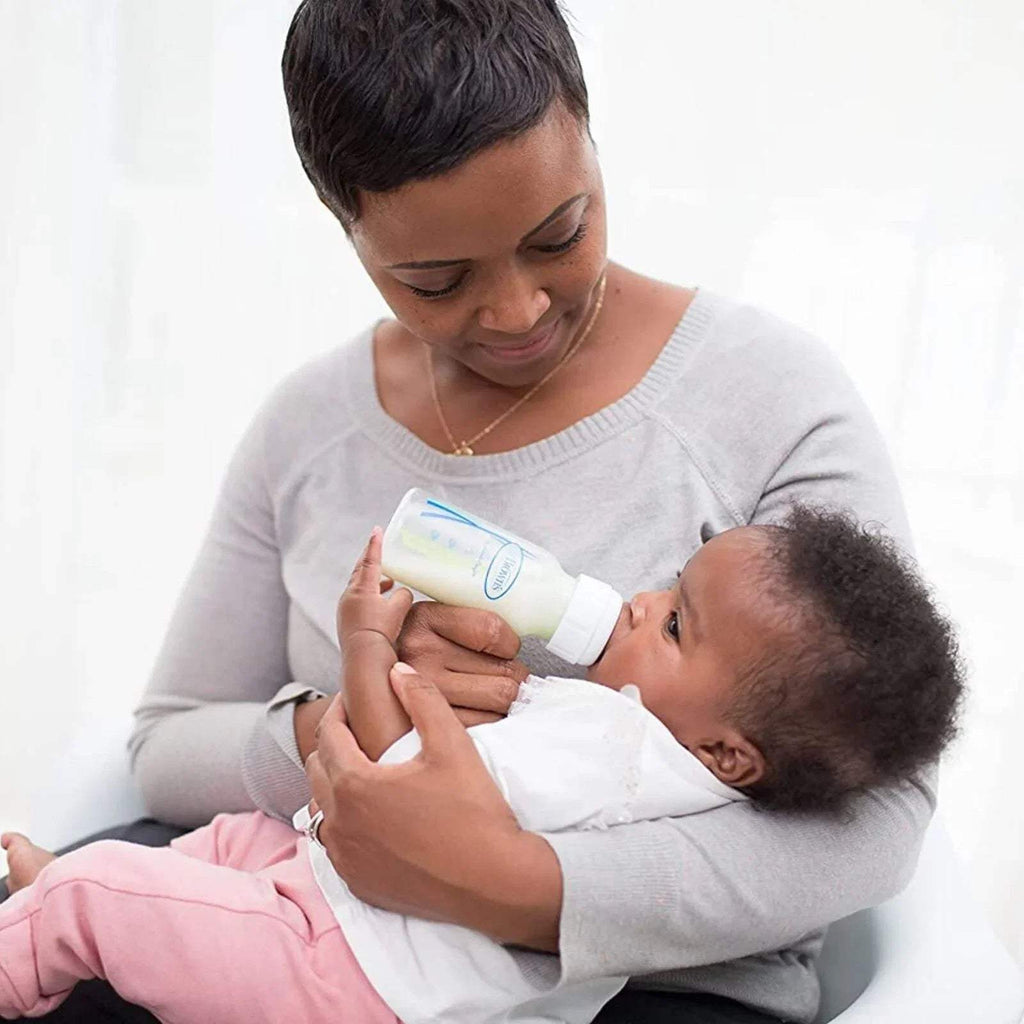 Baby bottle with narrow neck held to infant during feeding by adult