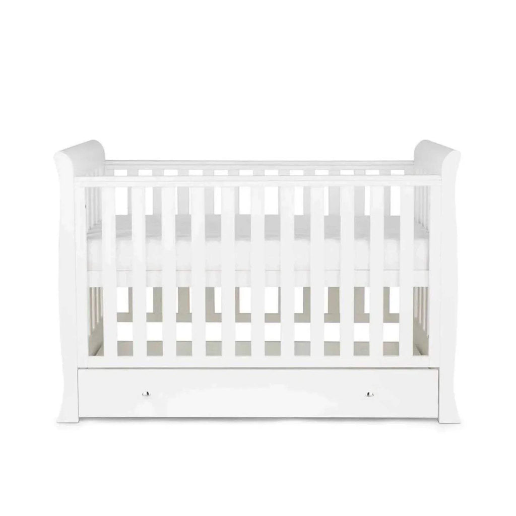 White baby crib with slatted rails and drawer front panel, side view