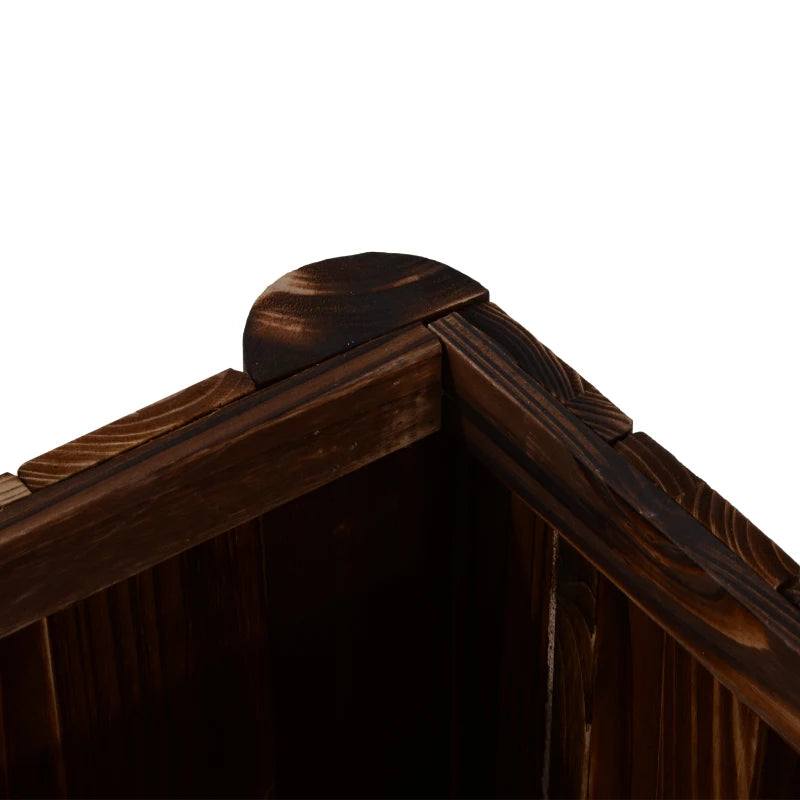 Corner of a dark carbonized wooden raised garden bed with joined top frame