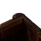 Corner of a dark carbonized wooden raised garden bed with joined top frame