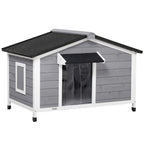 Grey wooden outdoor dog kennel with black roof mat, front door, and window panels