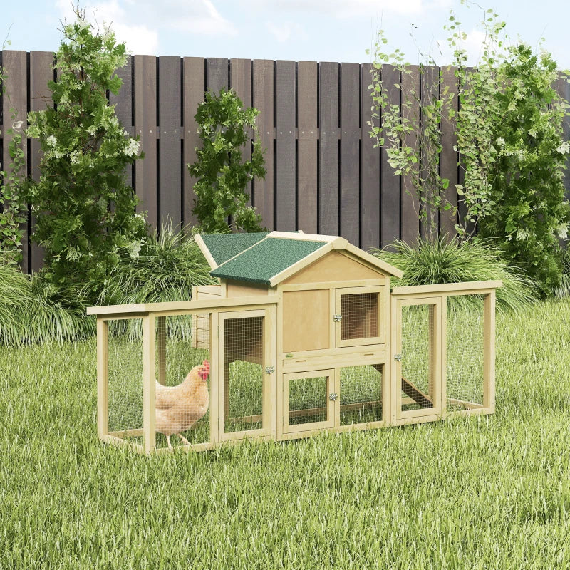Large wooden chicken coop with green shingled roof, wire mesh sides, and ramp