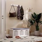 White shoe storage bench with gray cushion and three slatted drawer compartments