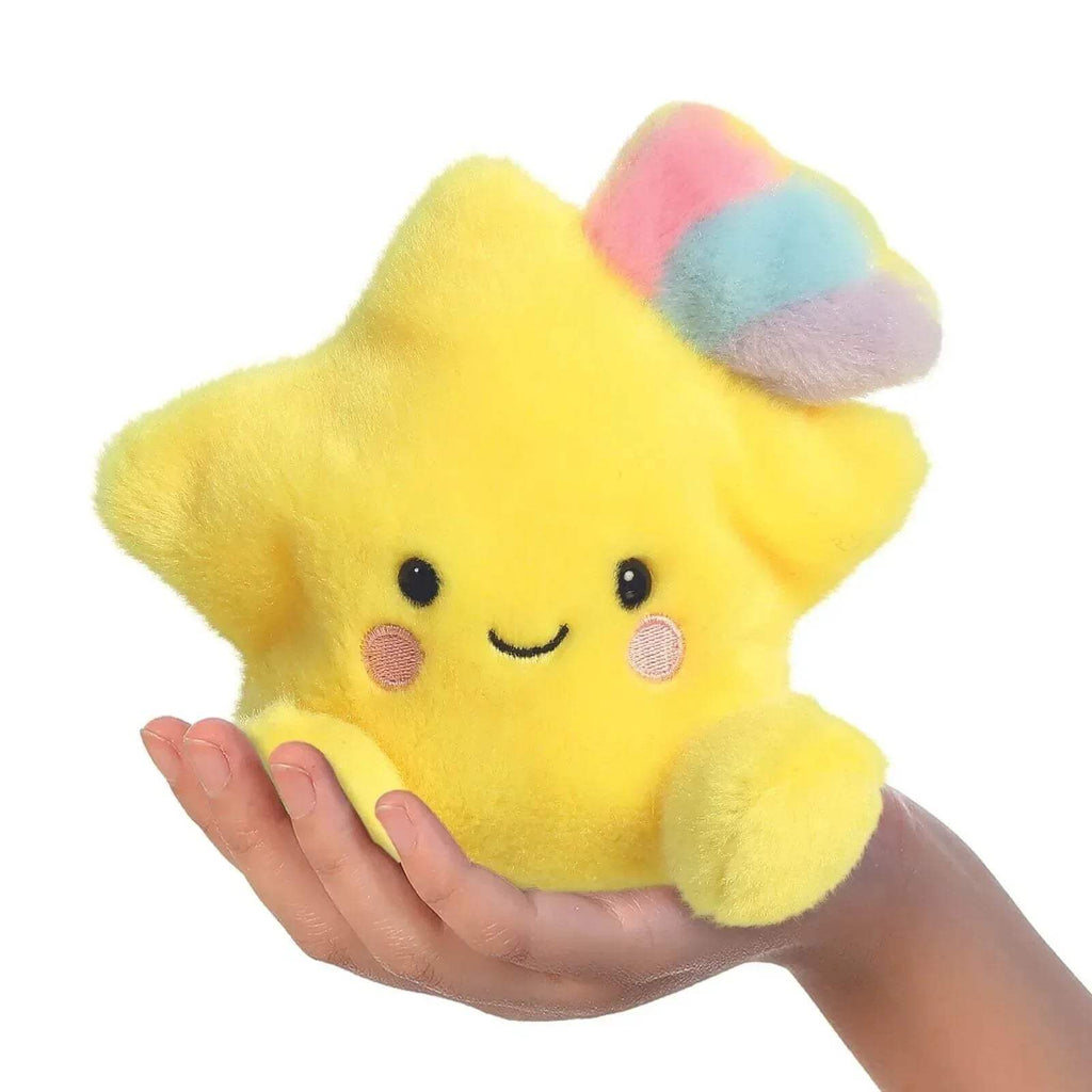 Yellow plush shooting star soft toy with face and pastel cloud tail, held in hand