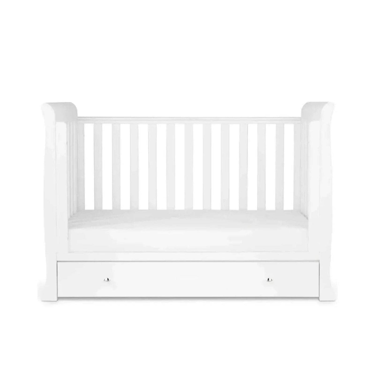 White mini crib with slatted sides, open mattress space, and front drawer