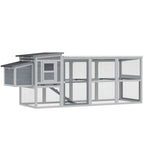Grey wooden chicken coop with covered run, wire mesh walls, and asphalt roof