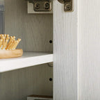 White cabinet door edge with hinge hardware and visible interior wall shelf