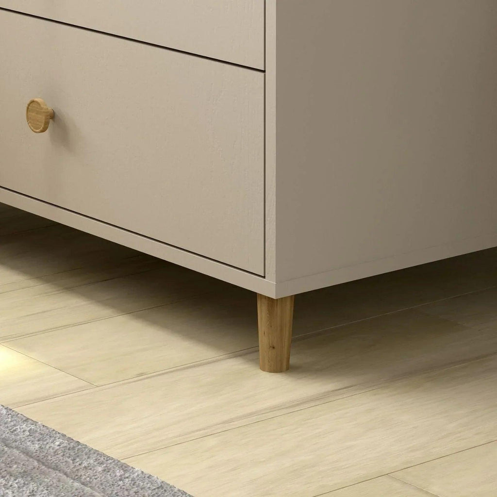 Kids changing dresser close-up of brass knob, drawer trim, and light wood legs