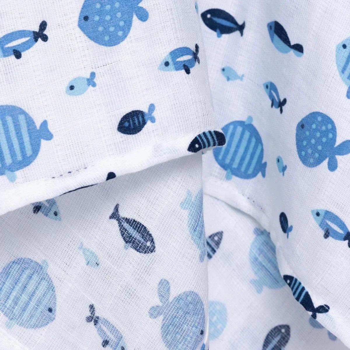 Blue muslin baby blanket corner close-up with layered fold and fish print
