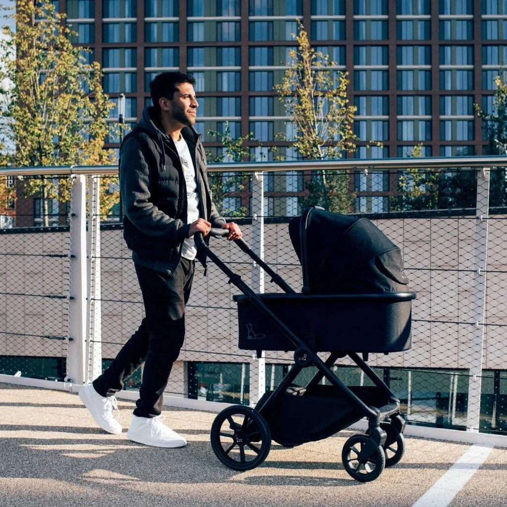 Black pushchair with black canopy and padded seat, four-wheel stroller
