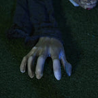 Zombie decoration hands with long fingers and glowing red eyes, grey fabric