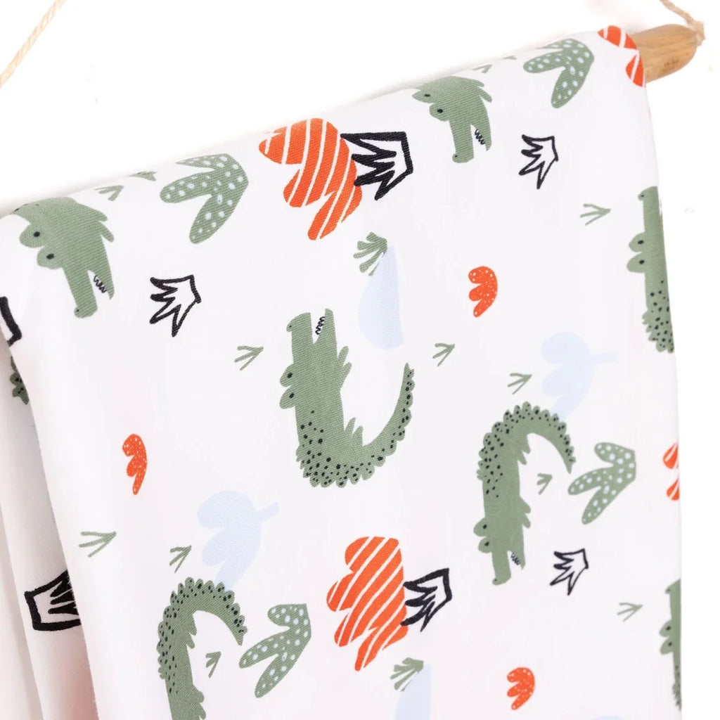 Close view of white kids blanket with cactus prints and orange heart details