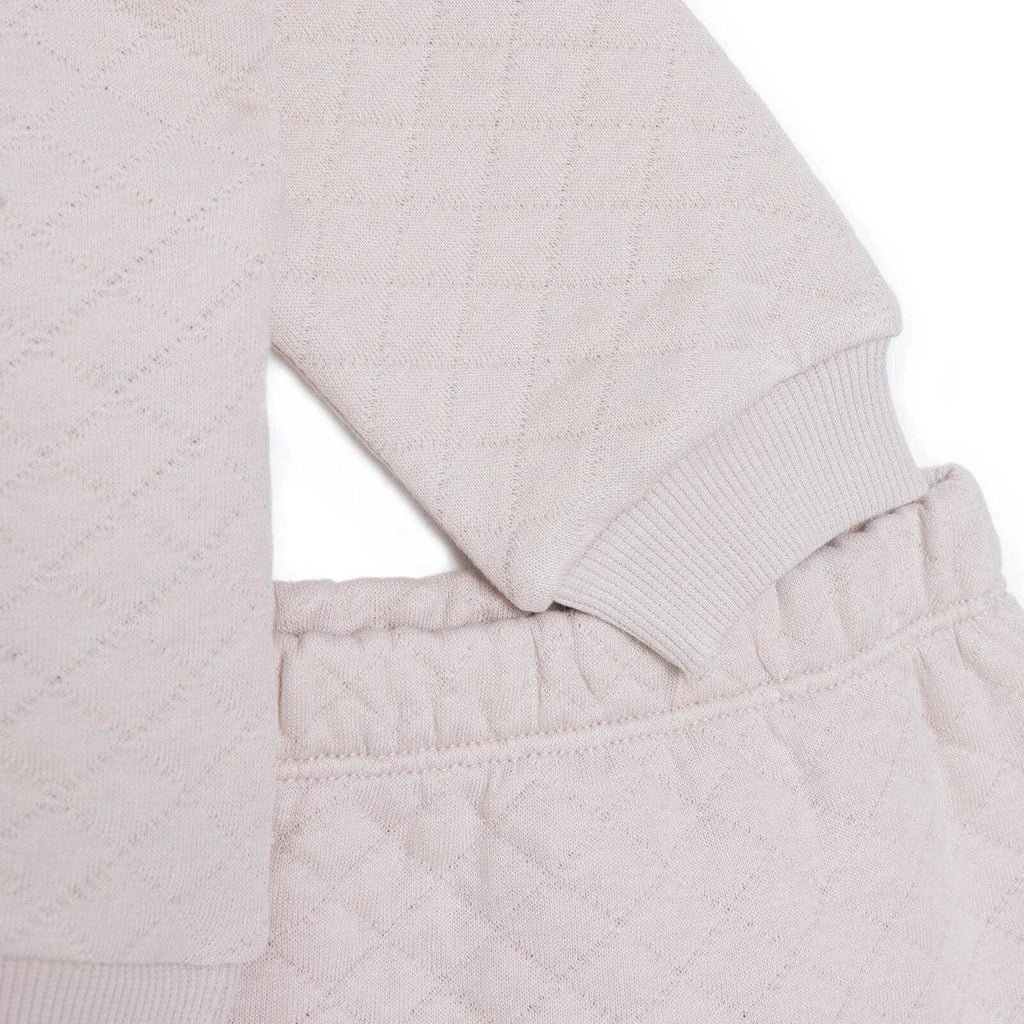Beige quilted baby sweatshirt hem and leggings waistband with stitched seam
