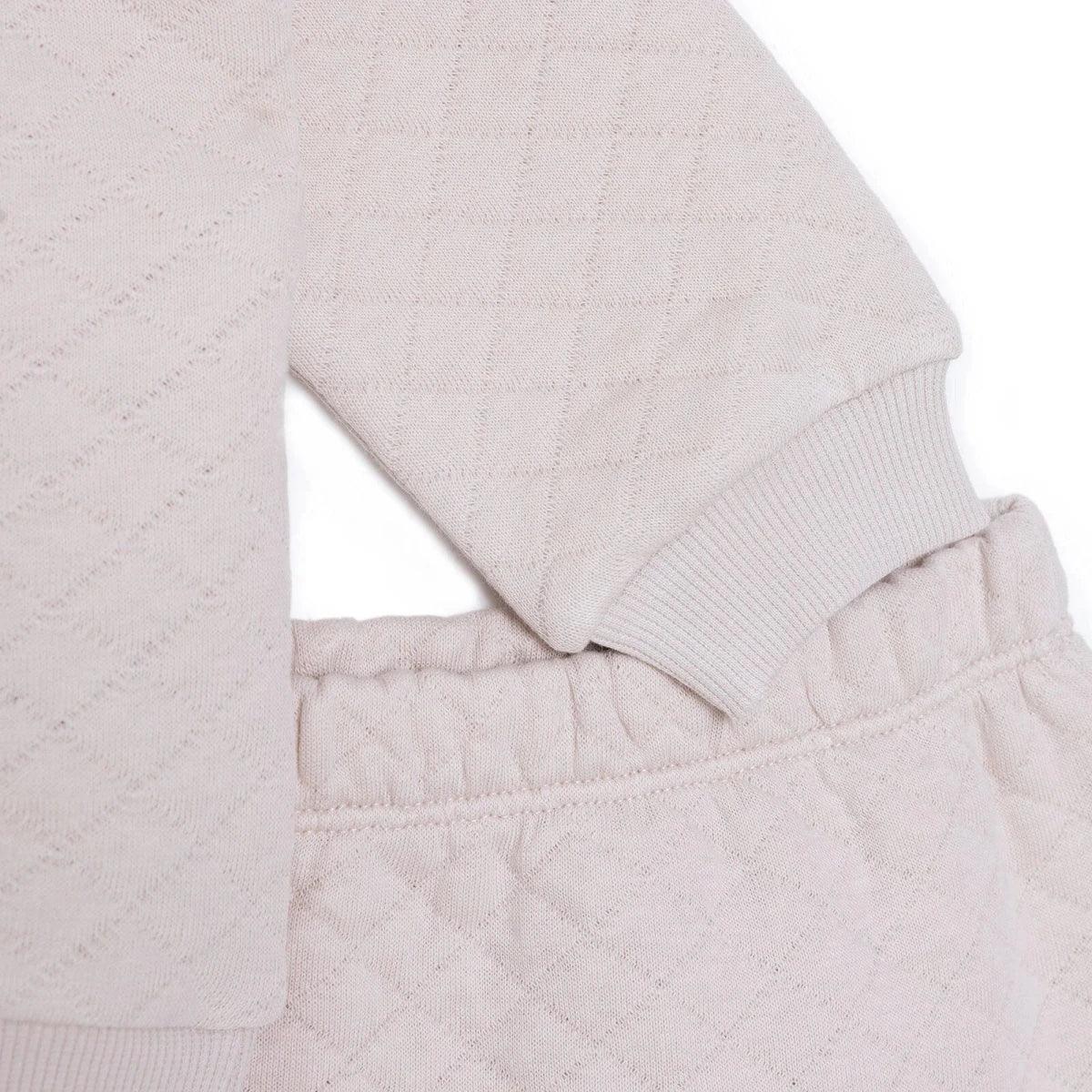 Beige quilted baby sweatshirt hem and leggings waistband with stitched seam