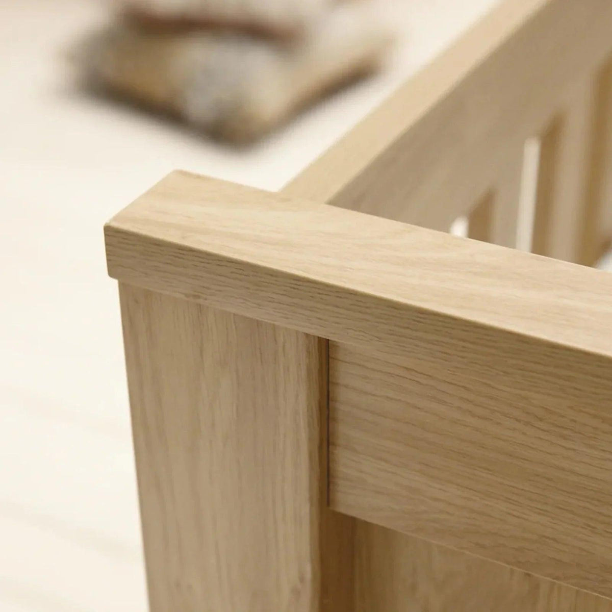 Oak cot bed end rail close-up with smooth wood grain finish