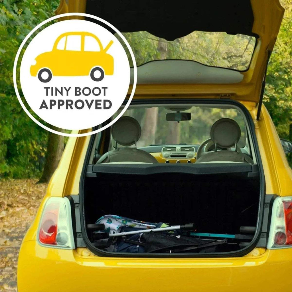 Printed 3-wheel stroller folded in open car trunk, showing frame and seat