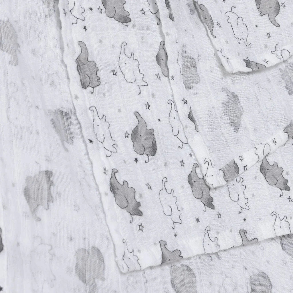 White muslin baby blanket with gray elephants and small stars, visible fabric texture