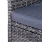 Grey upholstered seat cushion on woven rattan-style outdoor bench arm