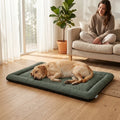 Green pet bed on the floor with a resting tan dog