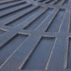 Close-up of dark textured resin on umbrella base weight plate with raised fan ridges