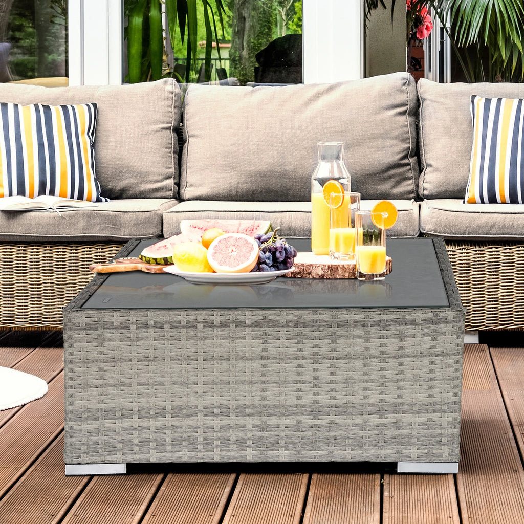Square gray wicker coffee table with glass top shown beside outdoor seating