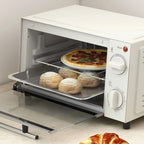 Cream mini oven with pizza and bread rolls on wire rack, door open