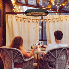 Black hanging patio heater with glowing halogen element and matching gray remote control.