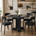 Black round drop-leaf dining table with opened leaves and four chairs around it