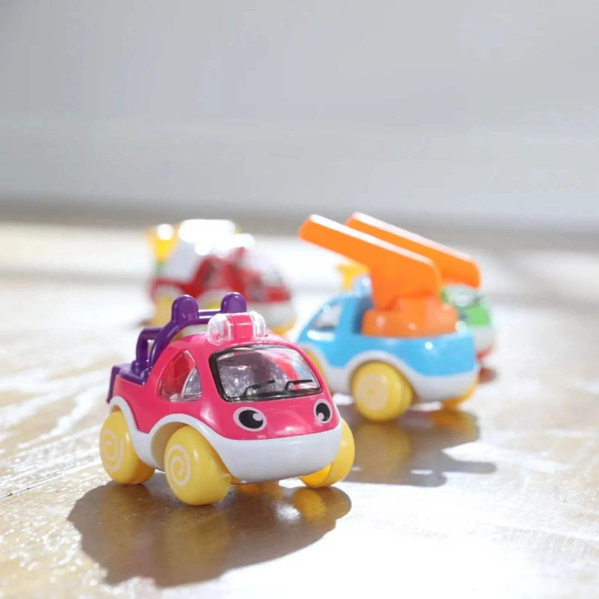 Mini toy car with red and white styling, with a blue and orange car behind it