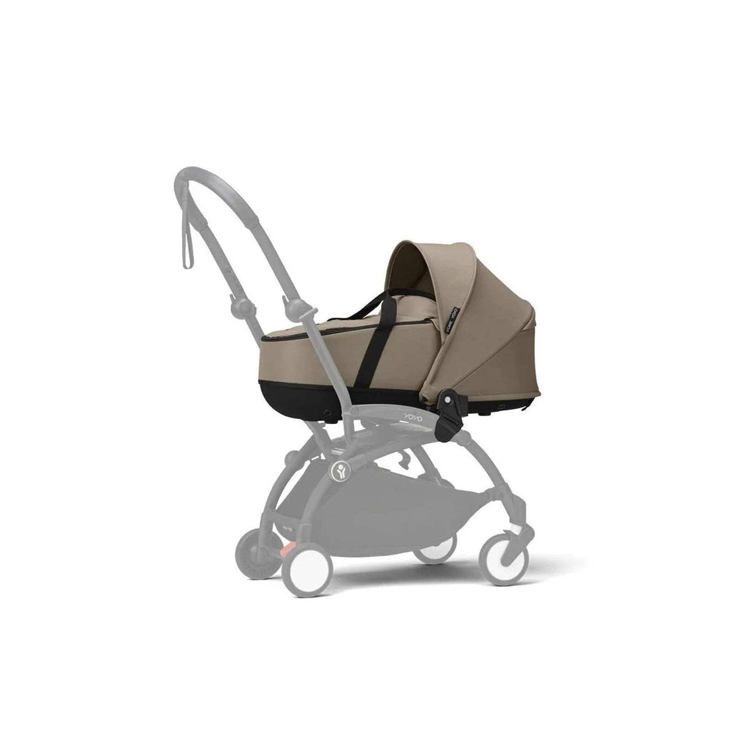 Taupe newborn shell on black stroller frame, with hood and carry handle