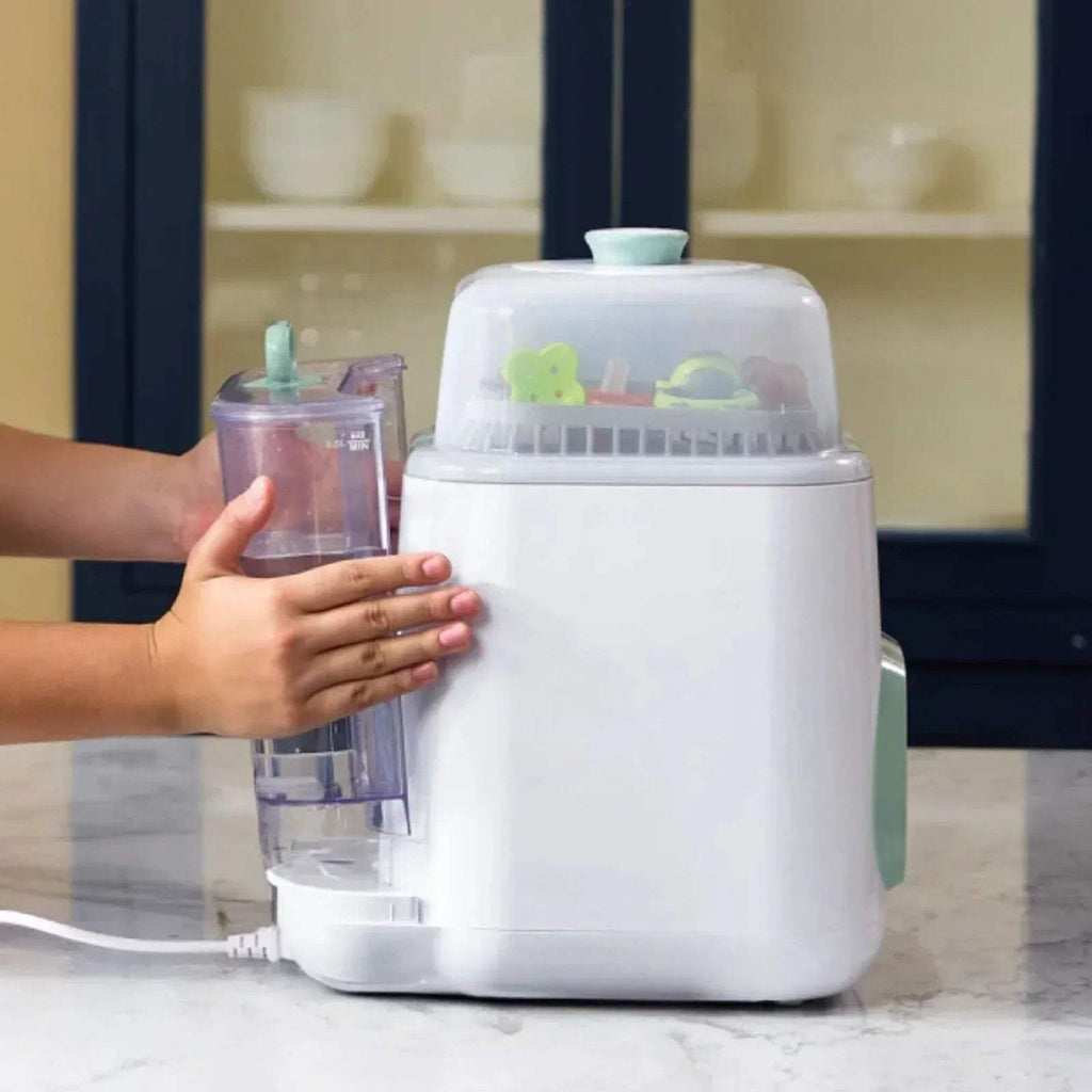 Hand placing bottle container into Momcozy baby bottle washer steriliser dryer lid