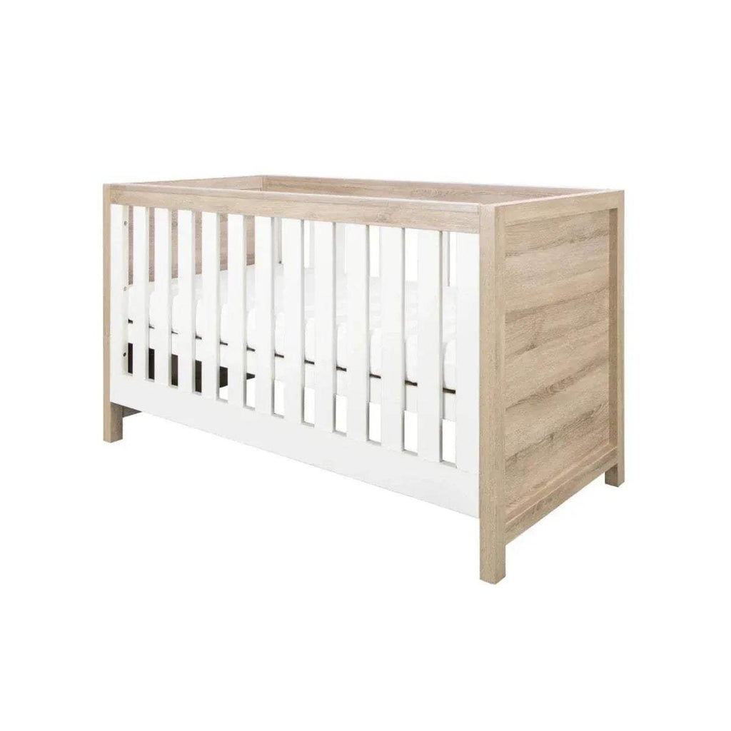 Light oak cot bed with white slatted sides and raised end panels, angled view.