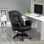Black faux leather executive chair with white contrast piping, shown beside an office desk