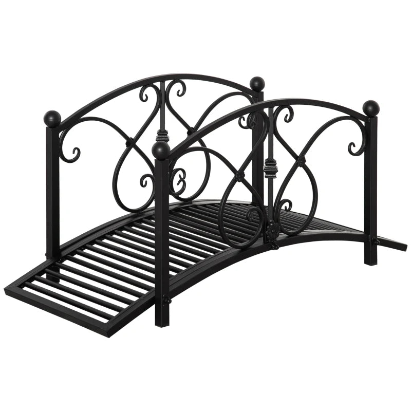 Black metal garden bridge with arched scrollwork safety railings and slatted walkway