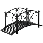 Black metal garden bridge with arched scrollwork safety railings and slatted walkway