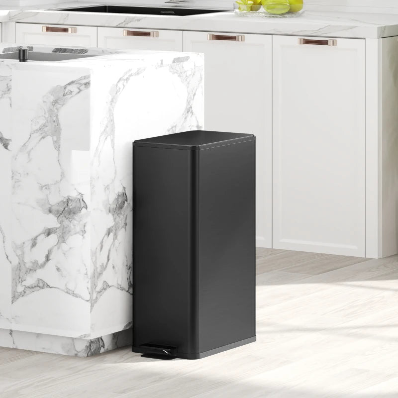 Black slim kitchen pedal bin beside a countertop with lid closed
