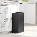 Black slim kitchen pedal bin beside a countertop with lid closed
