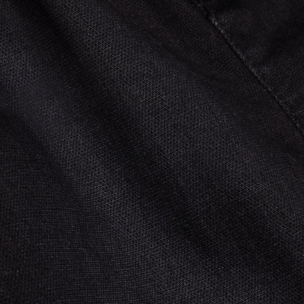 Black denim fabric close-up with fine woven texture