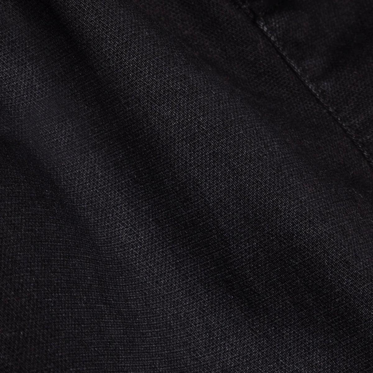 Black denim fabric close-up with fine woven texture