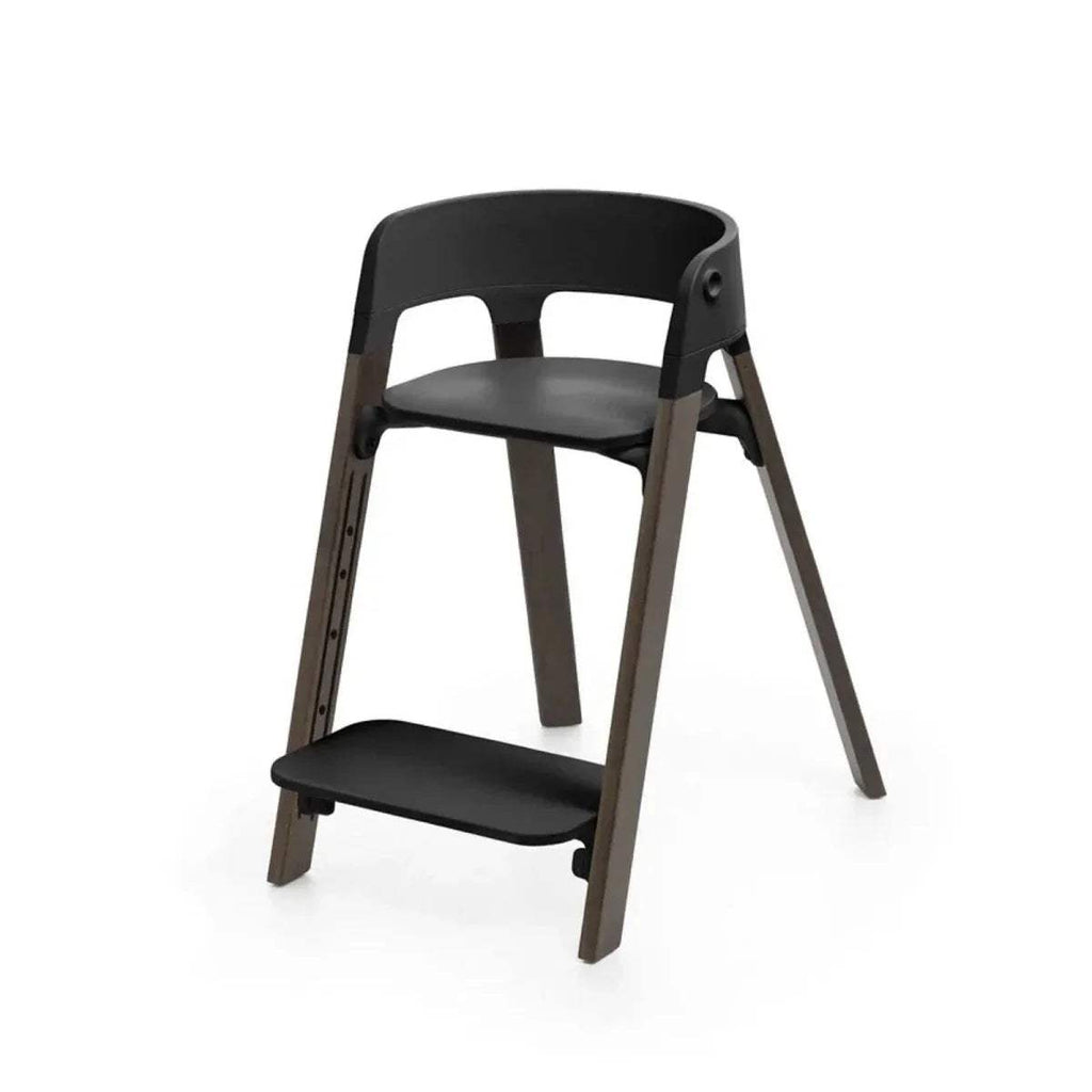 Black highchair with upper and lower seats, rounded backrest, warm brown frame
